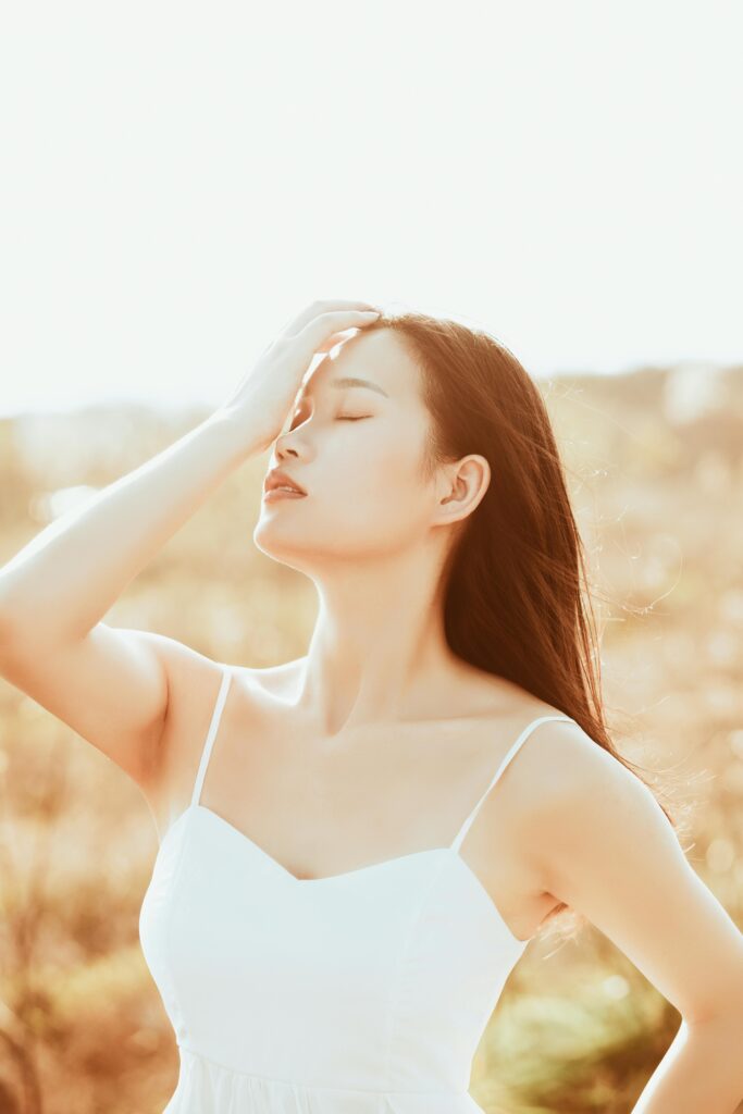 A serene portrait of a young woman basking in the warm summer sun, capturing beauty and tranquility.